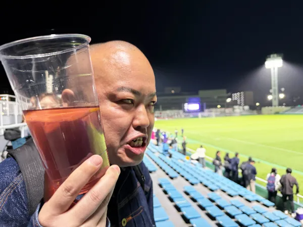観戦中に飲み物を持つ人