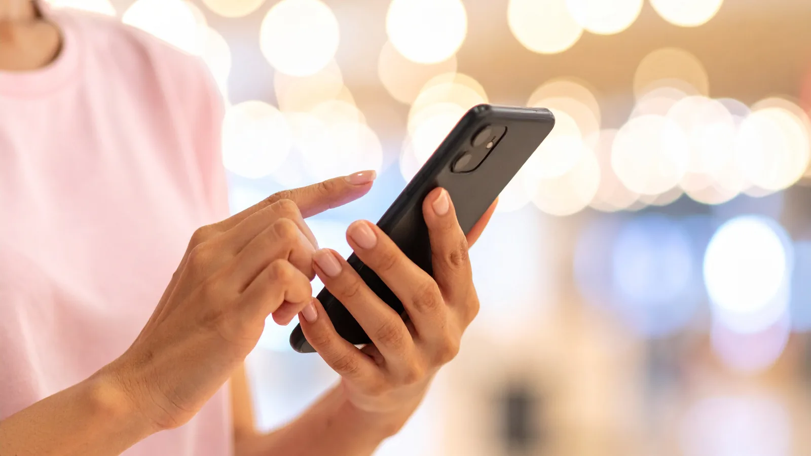 TikTok運用で使用するスマートフォンを操作する女性スタッフの手元