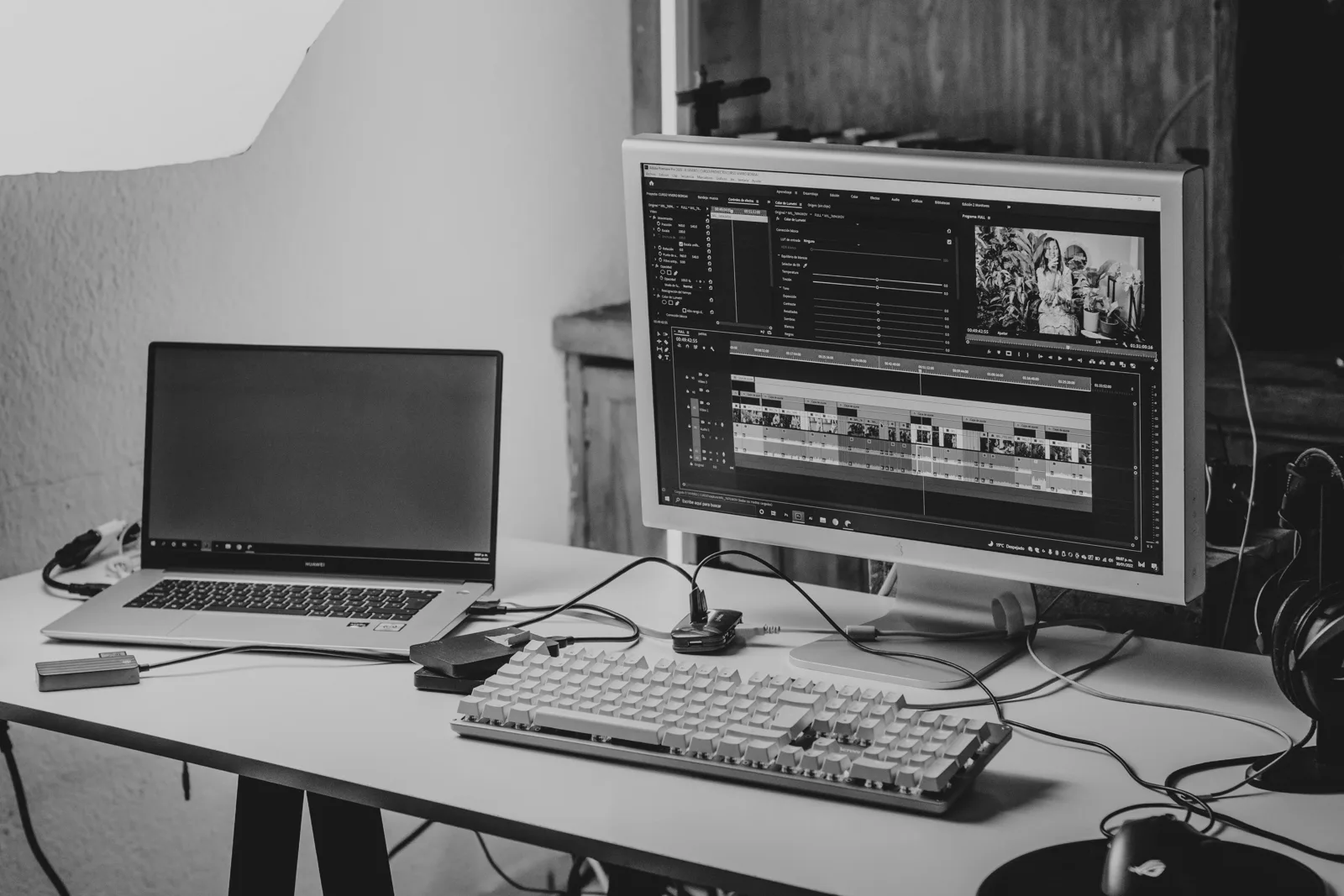 動画編集ソフトを表示したモニターとノートパソコンが並ぶ作業机のイメージ写真